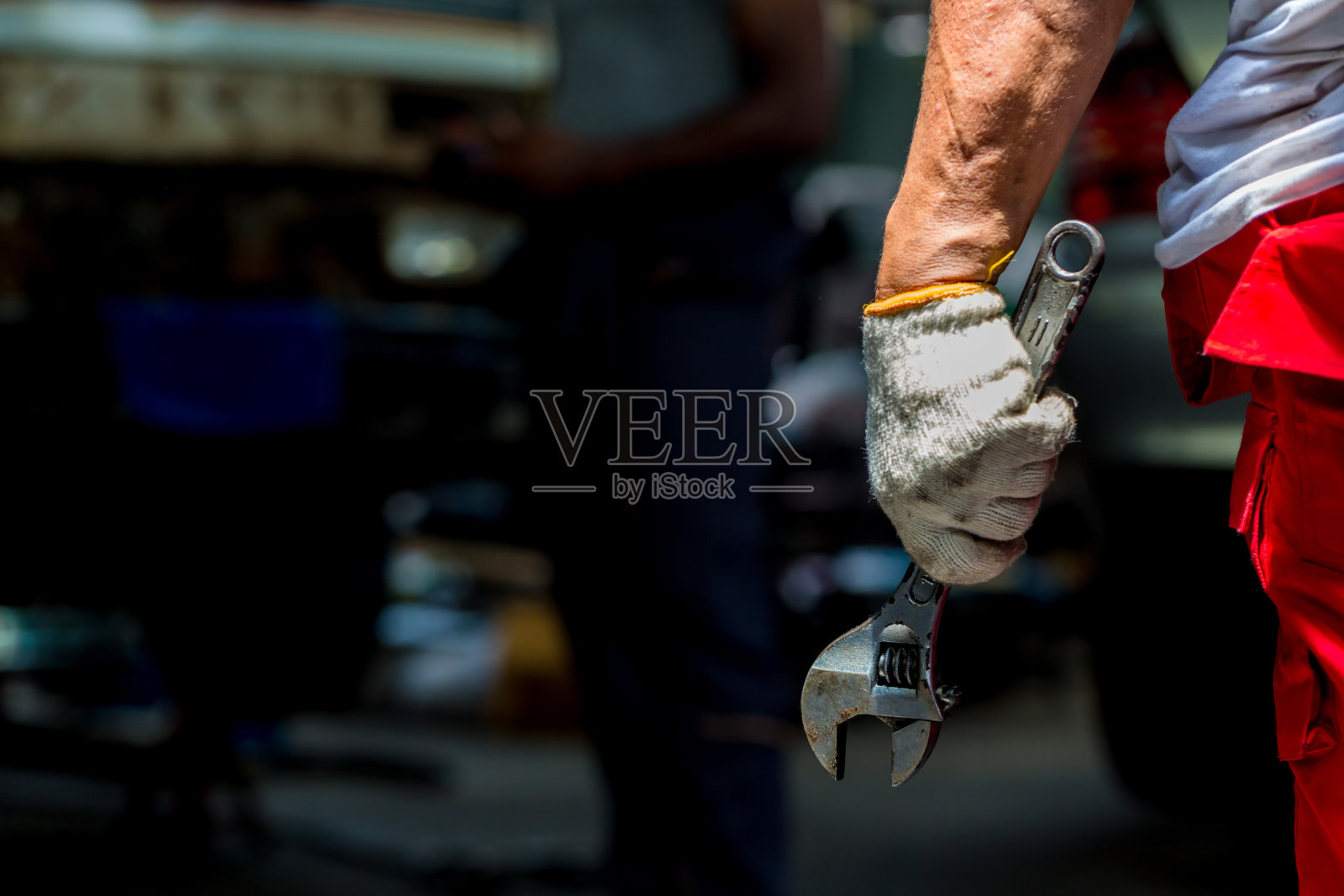 汽车修理工手中的扳手。手握金属扳手照片摄影图片