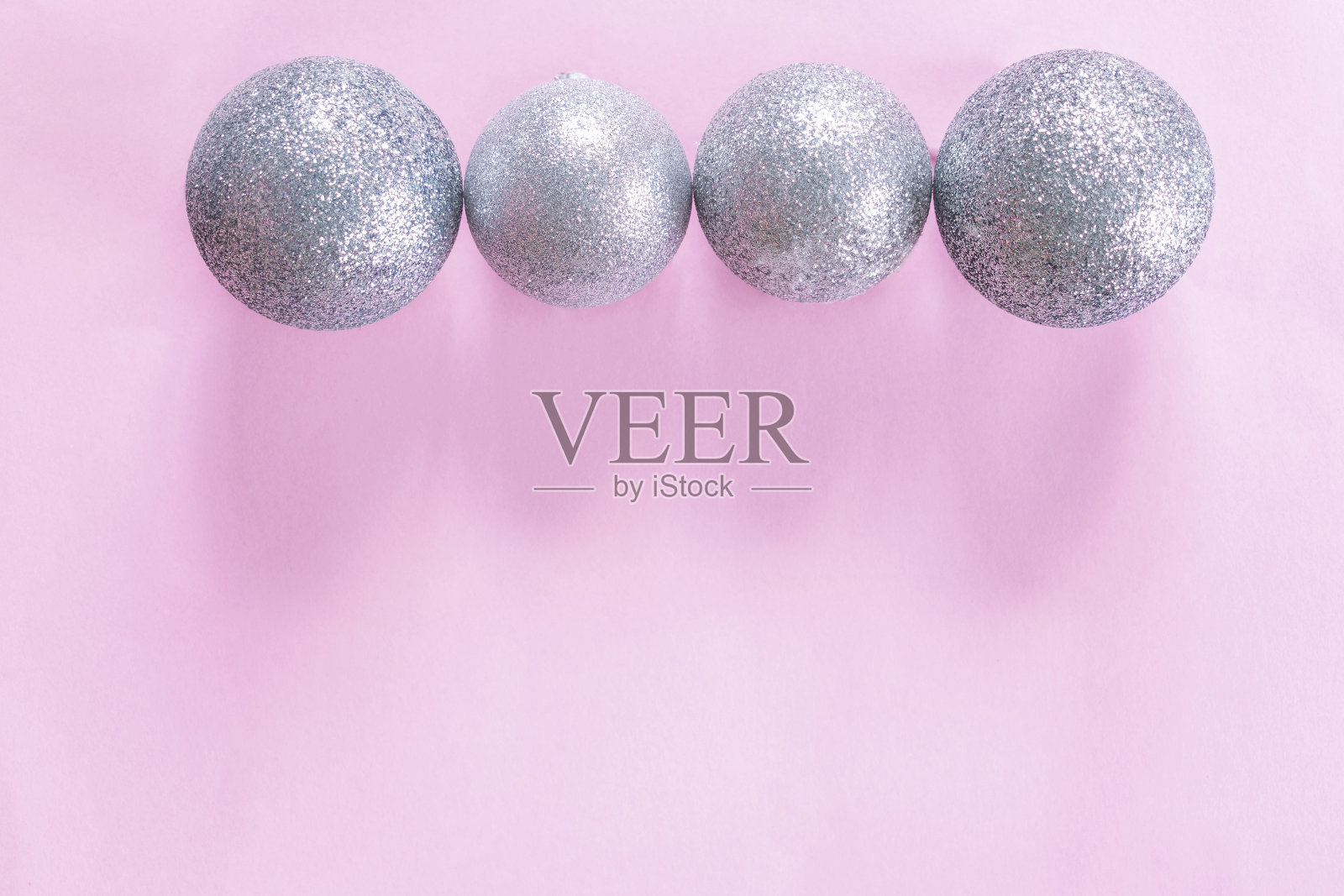 圣诞银球在粉红色的纸背景与拷贝空间。新年装饰品摆放整齐照片摄影图片