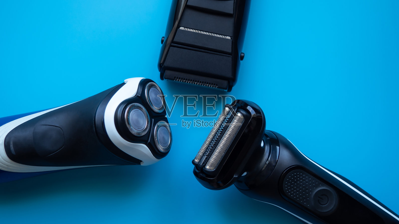 不同类型的电动剃须刀在蓝色背景特写。剃须刀。男性组。照片摄影图片