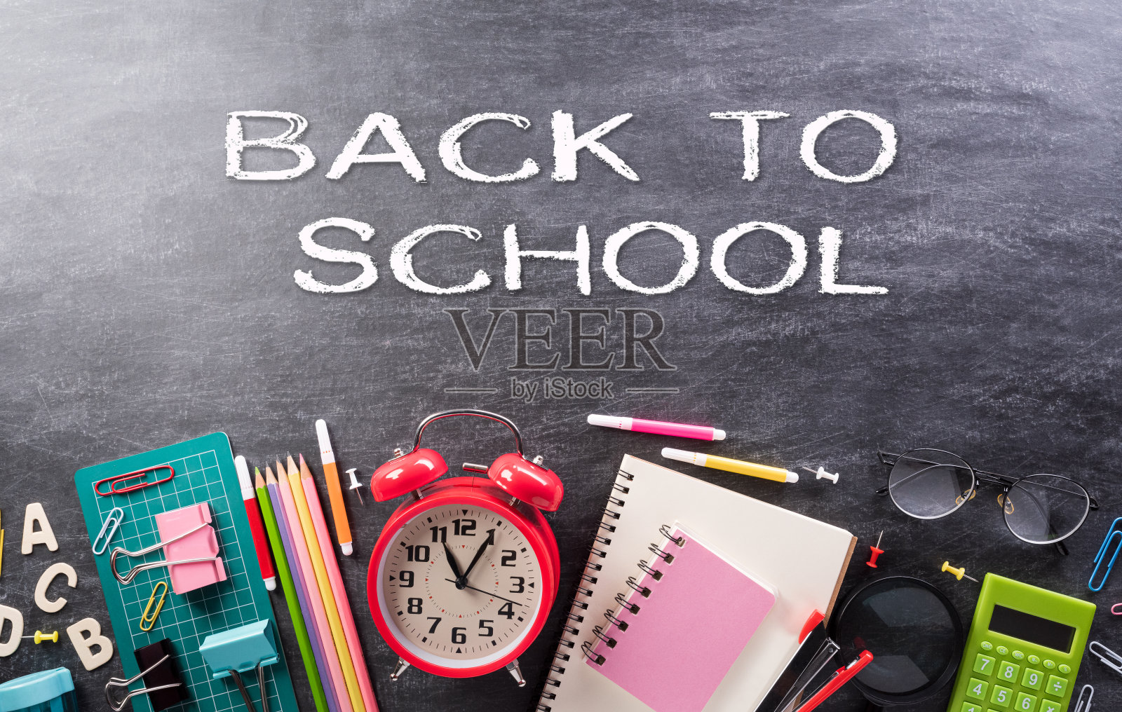 教育还是返校的概念。顶视图丰富多彩的学校用品与书，彩色铅笔，计算器，钢笔，刀具和剪辑在背板的背景。照片摄影图片