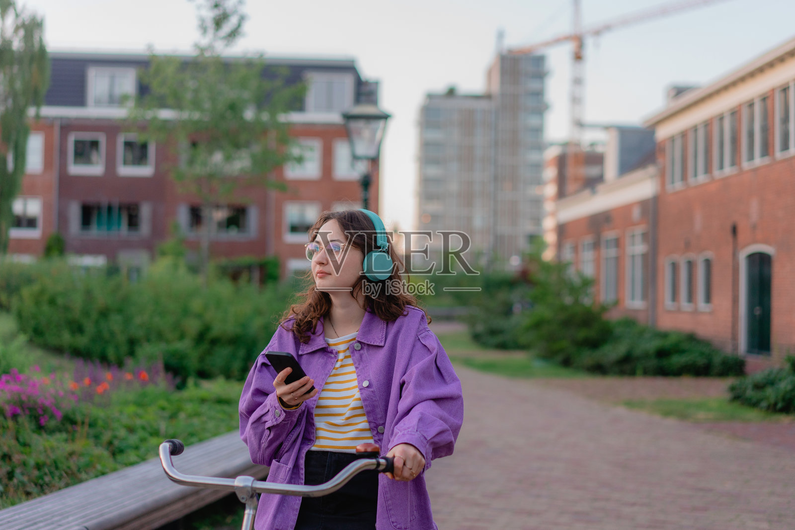 一个女人在日落时分骑着自行车在城里照片摄影图片