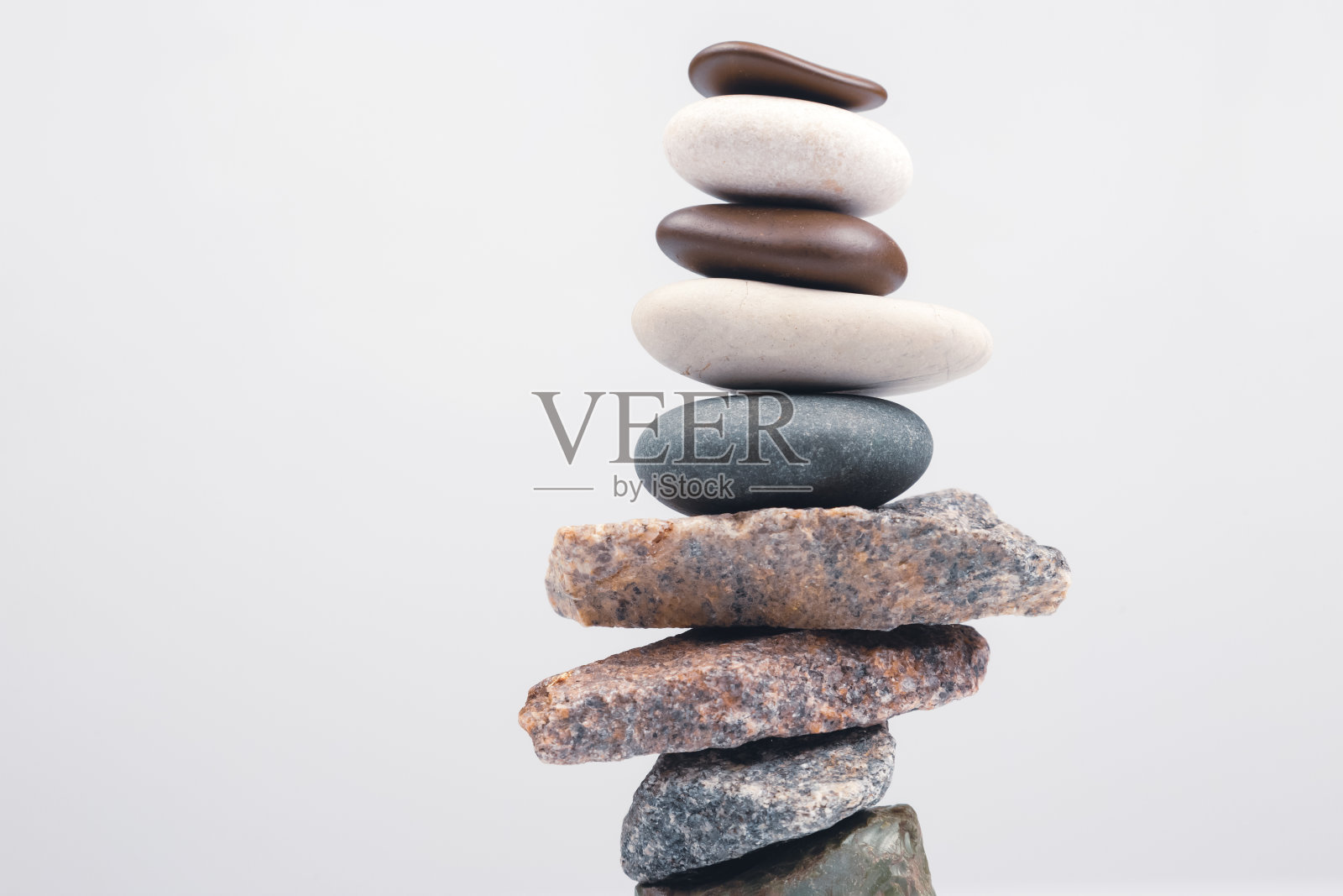 金字塔堆叠的石头在一个明亮的背景。生活中的稳定与平衡照片摄影图片