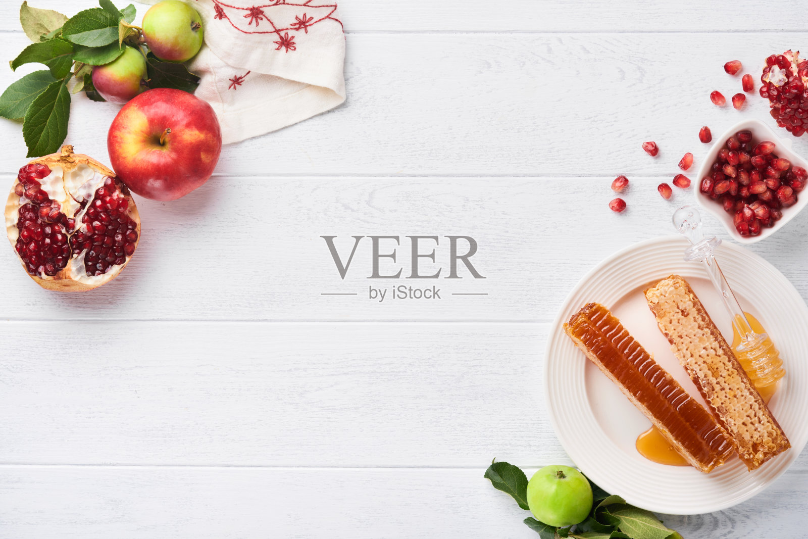 犹太新年。蜂蜜罐，蜂巢，苹果和石榴在白色木制旧质朴的背景表。犹太新年节日贺卡。犹太新年的节日属性。空间的文本照片摄影图片