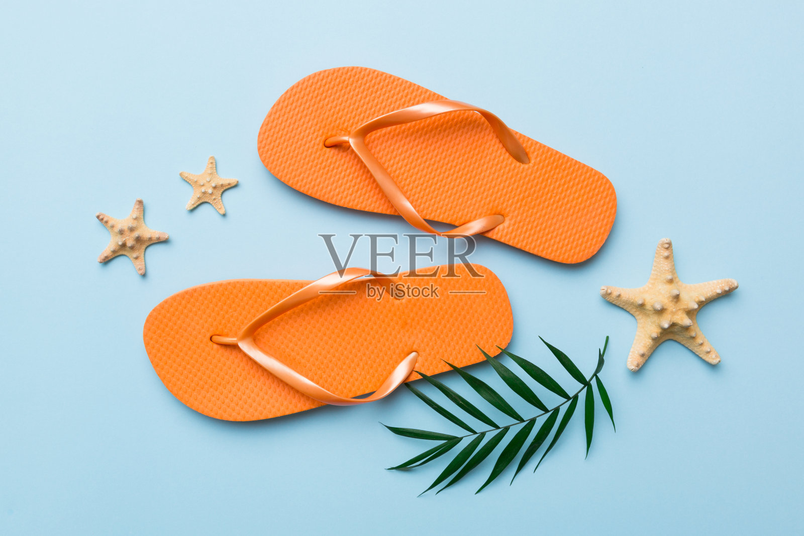 平面布局与彩色背景上的人字拖和贝壳组成。文本俯视图的空间照片摄影图片