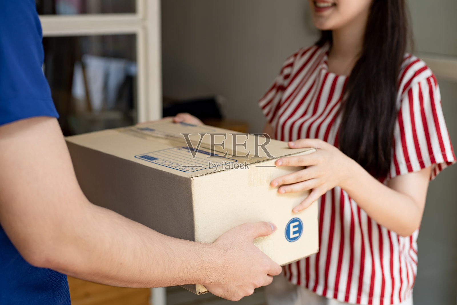 这位女士收到了快递包裹。照片摄影图片