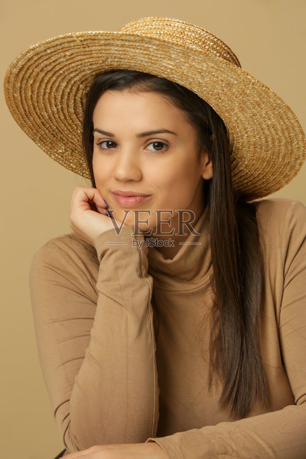 穿着米色高领毛衣和草帽的漂亮年轻黑发女郎肖像照片摄影图片
