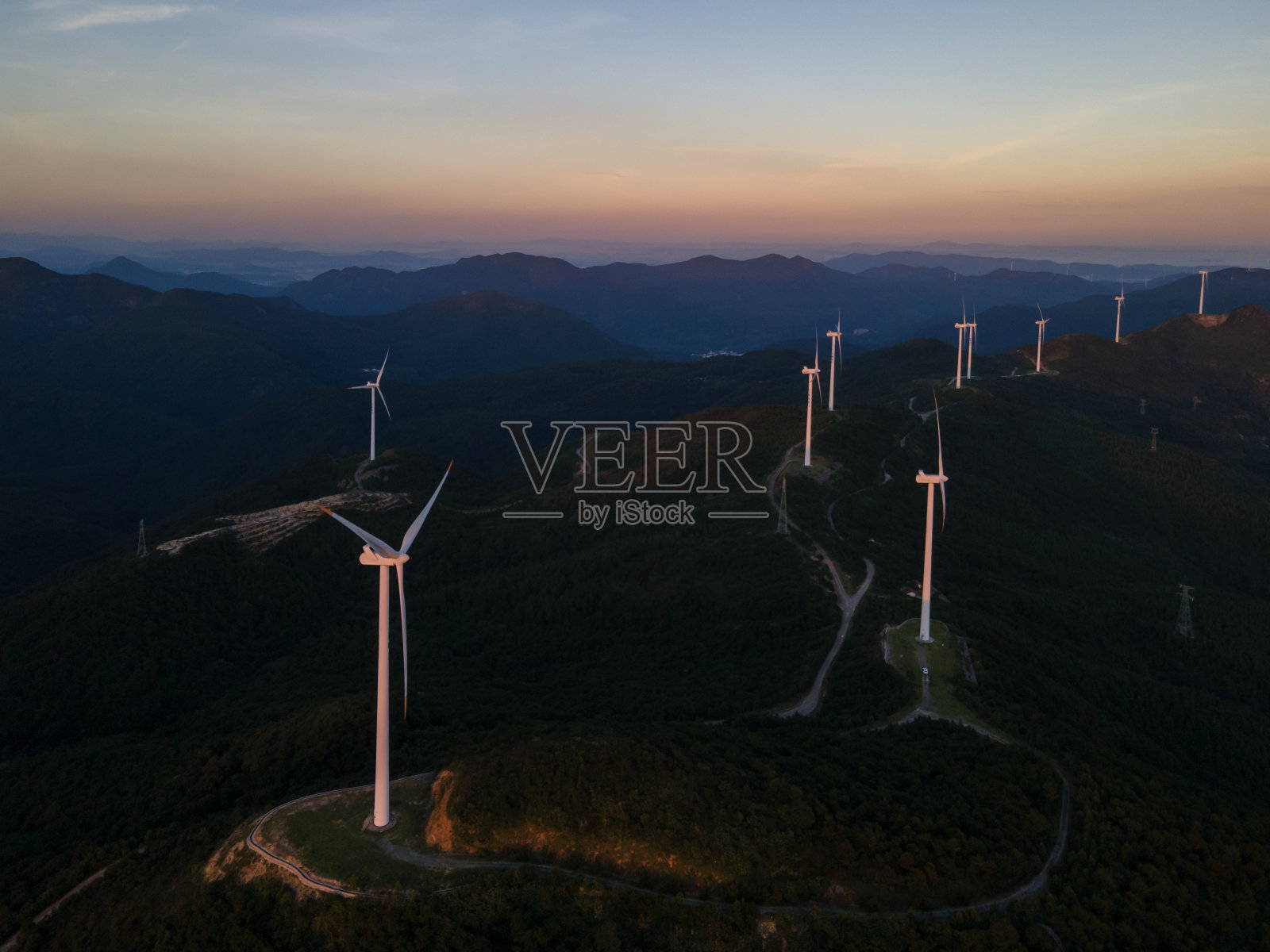 黄昏时分山顶上的风力发电机组鸟瞰图照片摄影图片