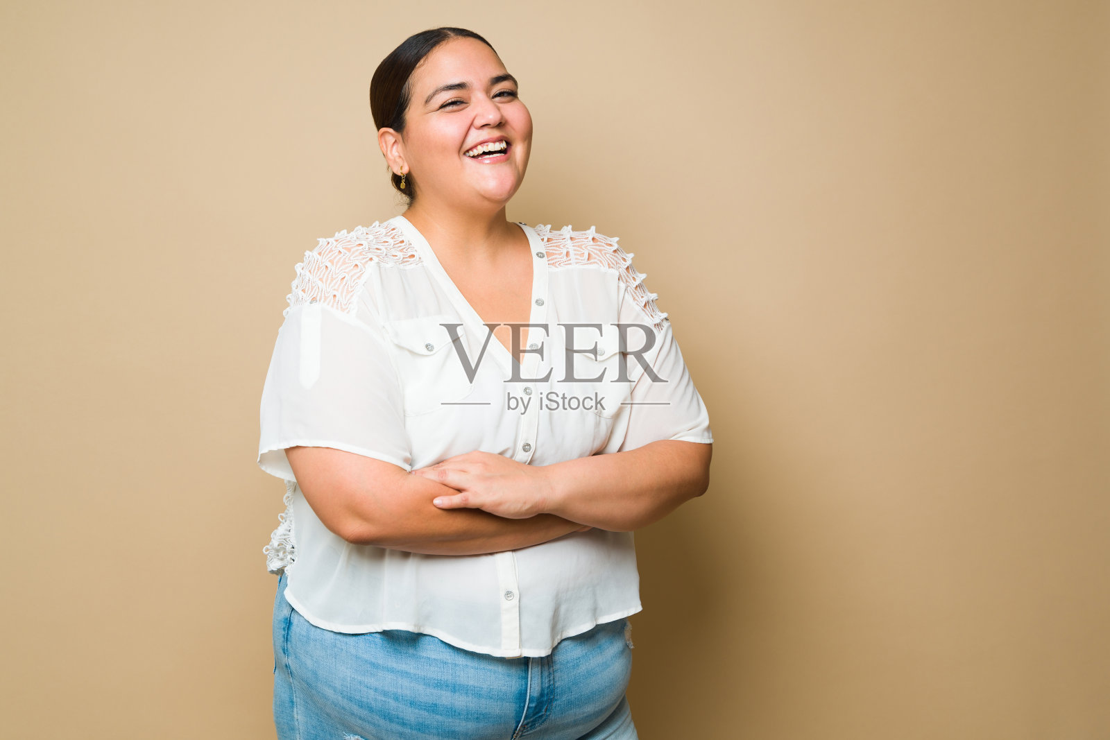 欢快的胖拉丁女人在淡黄色的背景下微笑照片摄影图片