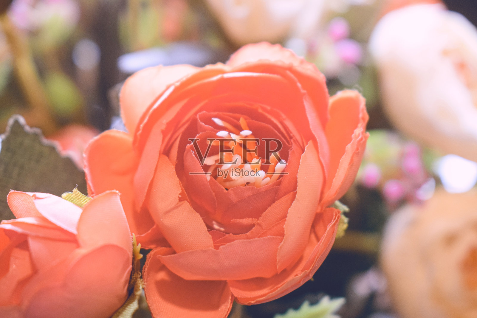 用硬织物制成的漂亮的橙色假花。客厅的装饰花。照片摄影图片