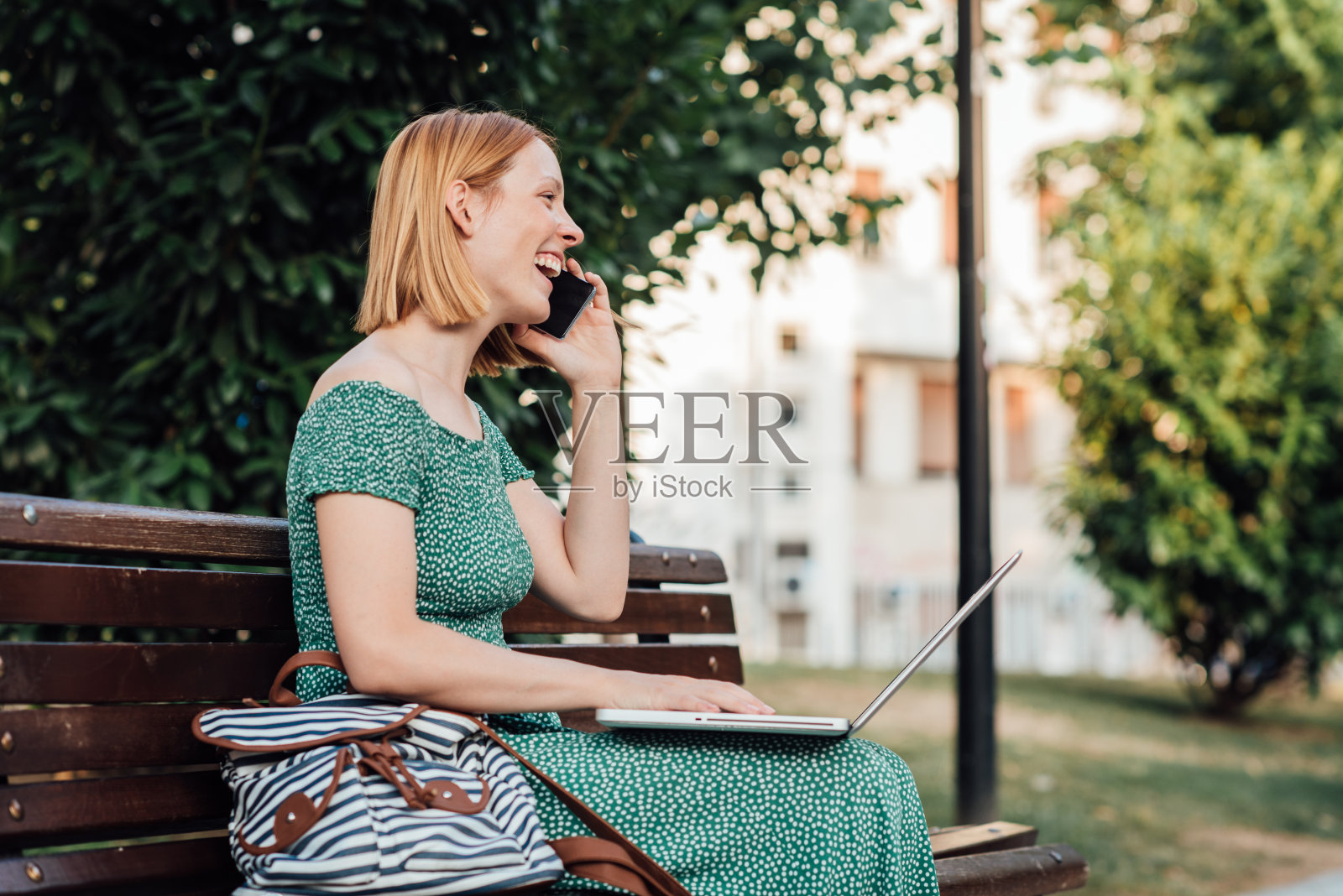 美丽的红发学生在户外学习时用手机聊天照片摄影图片