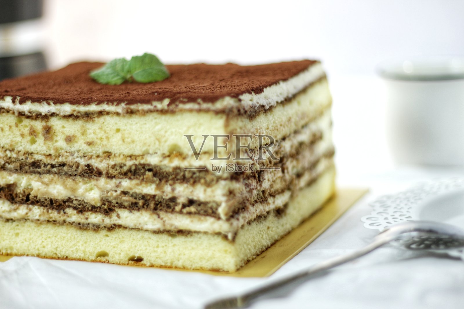 白色盘子上的提拉米苏蛋糕片。好吃又甜的自制蛋糕。分层的蛋糕。食物概念作为背景或墙纸。照片摄影图片