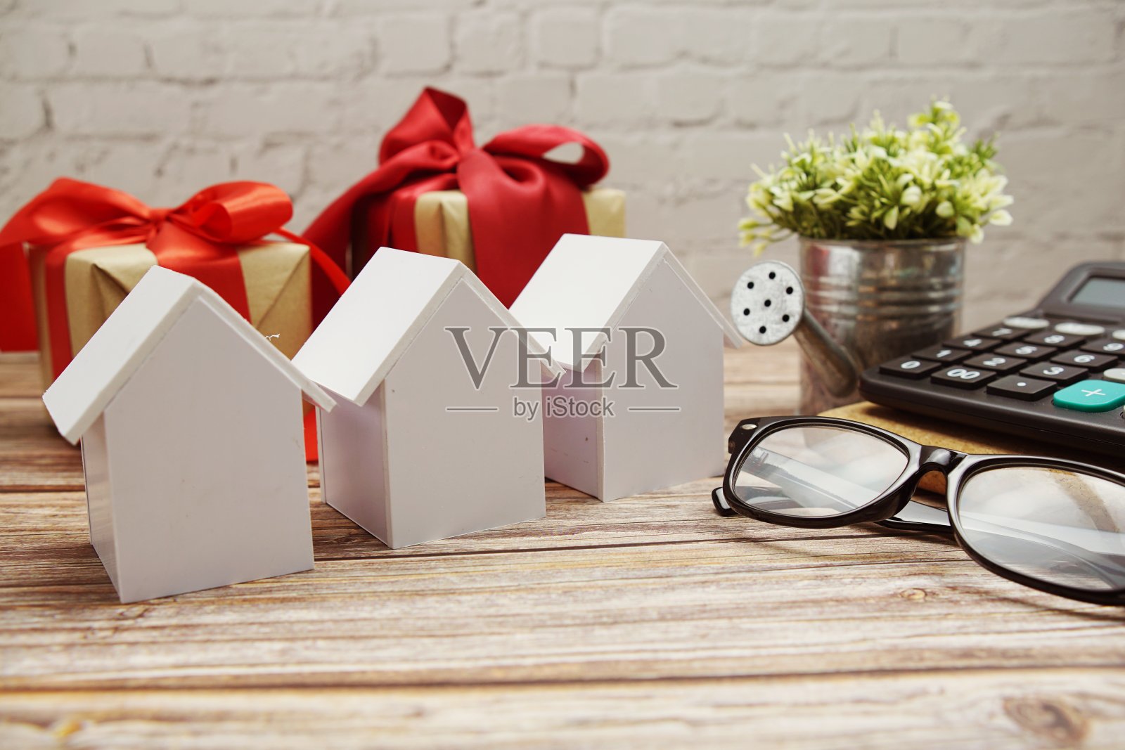 木制背景的模型房子和计算器，房地产概念照片摄影图片