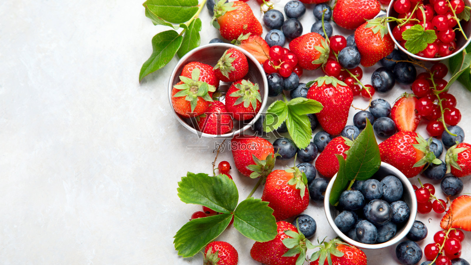 各种新鲜浆果在中性背景。照片摄影图片