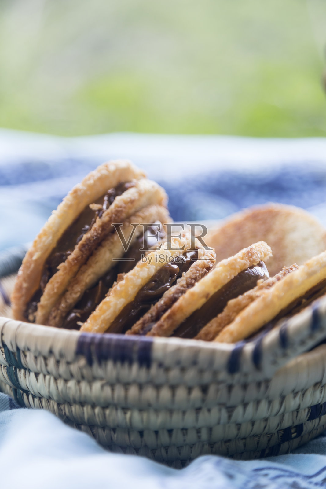 野餐时，柳条篮子里装着美味的焦糖椰子饼干照片摄影图片