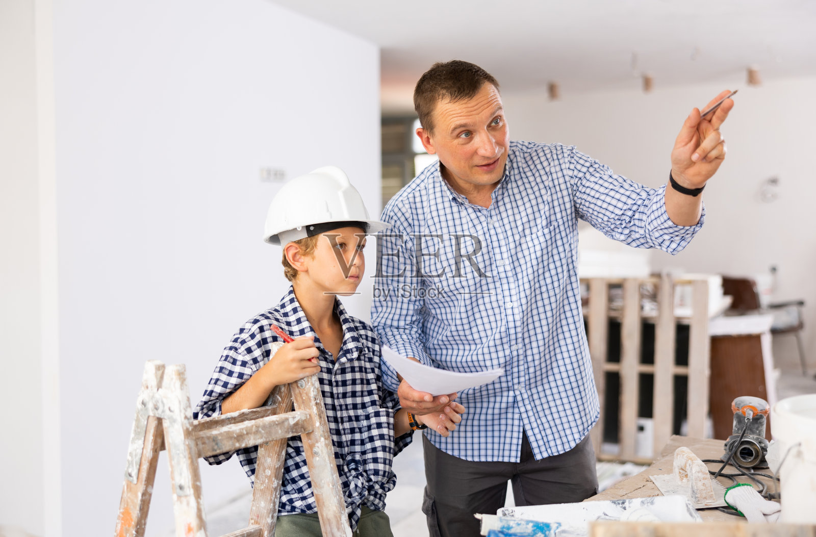 男人给儿子看新家的设计图照片摄影图片