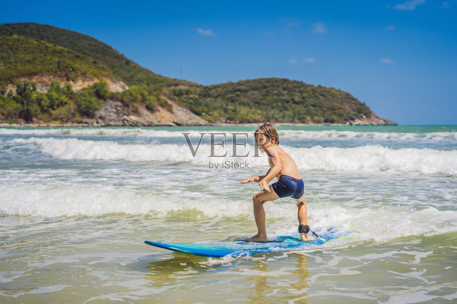 健康的小男孩学习在大海中冲浪照片摄影图片