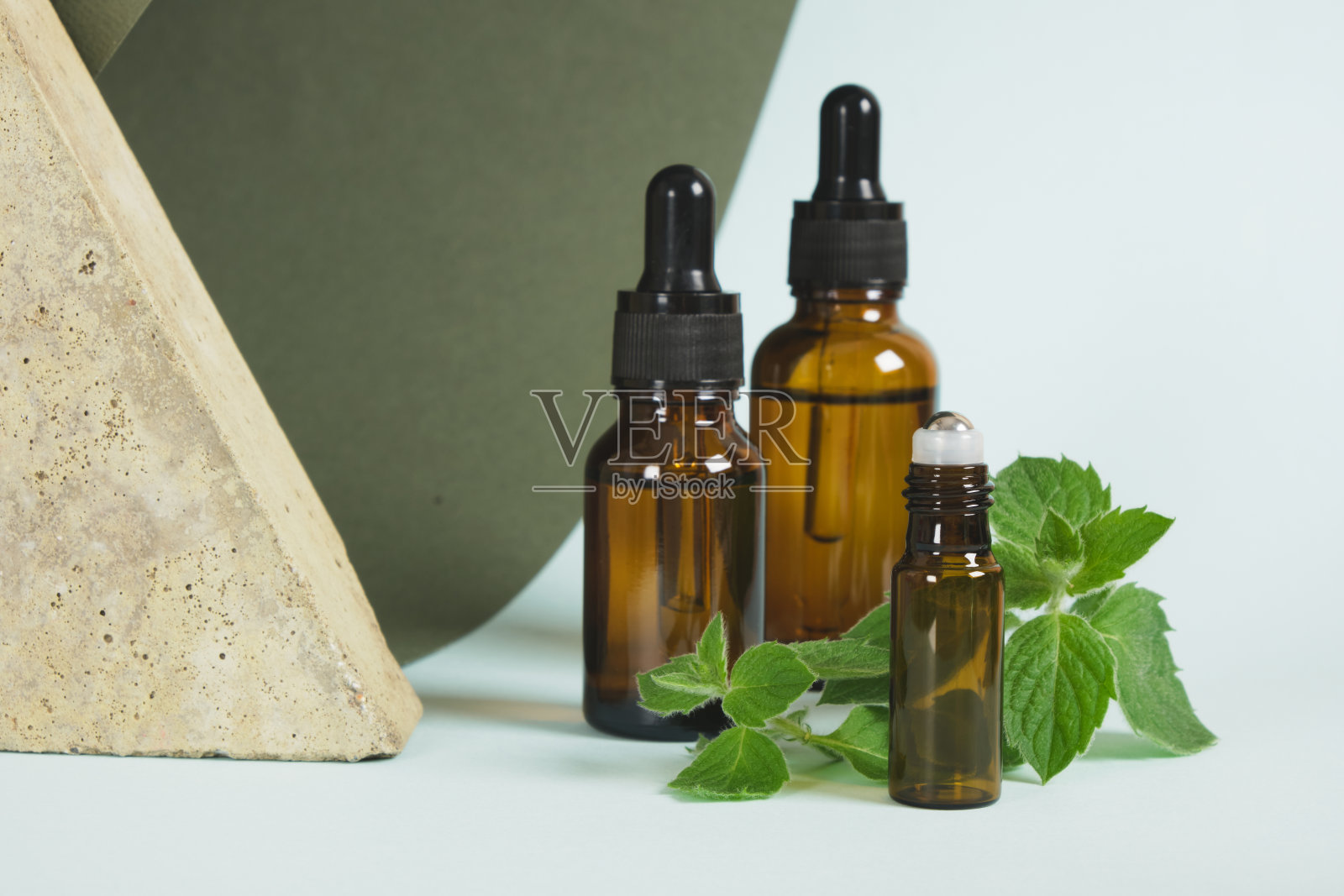 琥珀色的玻璃滴管和薄荷叶，薄荷油装在装有移液管的瓶子里照片摄影图片