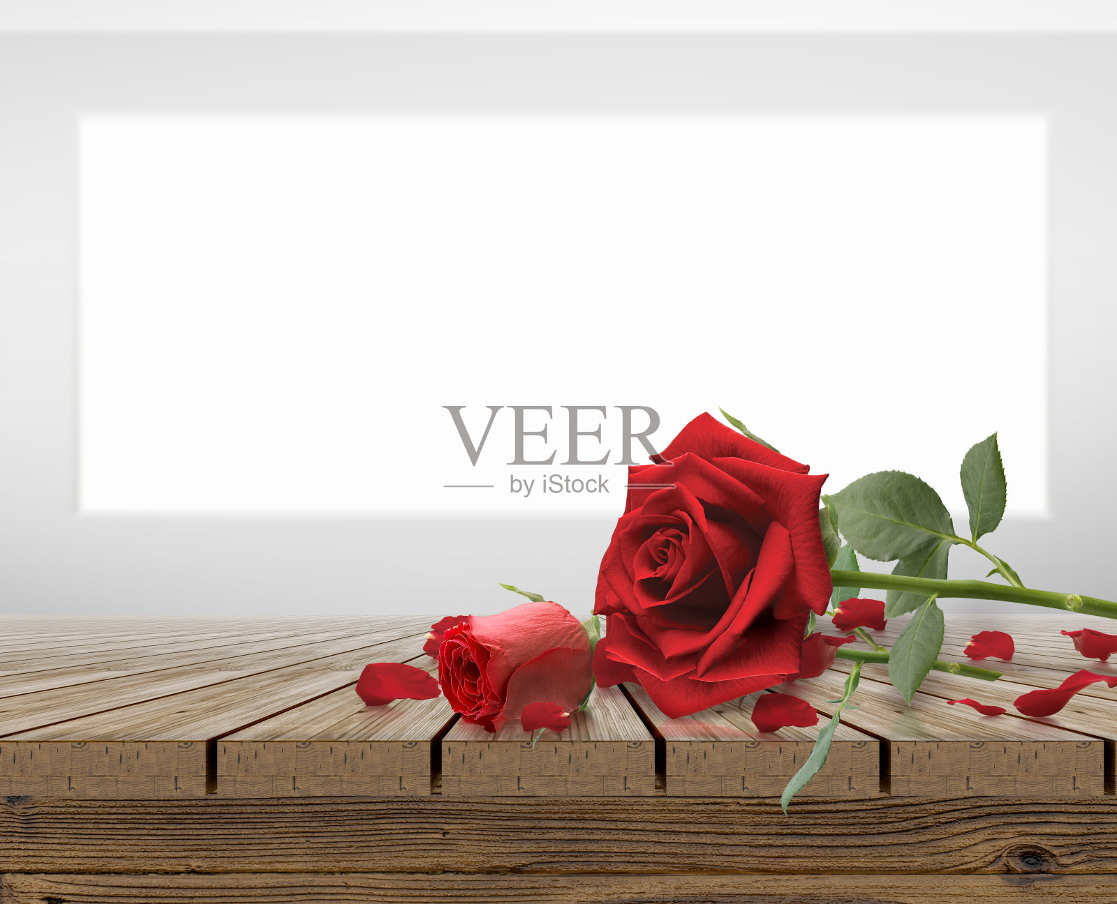 红玫瑰和玫瑰花瓣放在木制桌面照片摄影图片