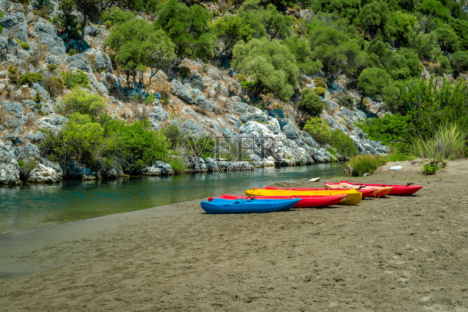 大自然中，流水旁的五彩独木舟照片摄影图片
