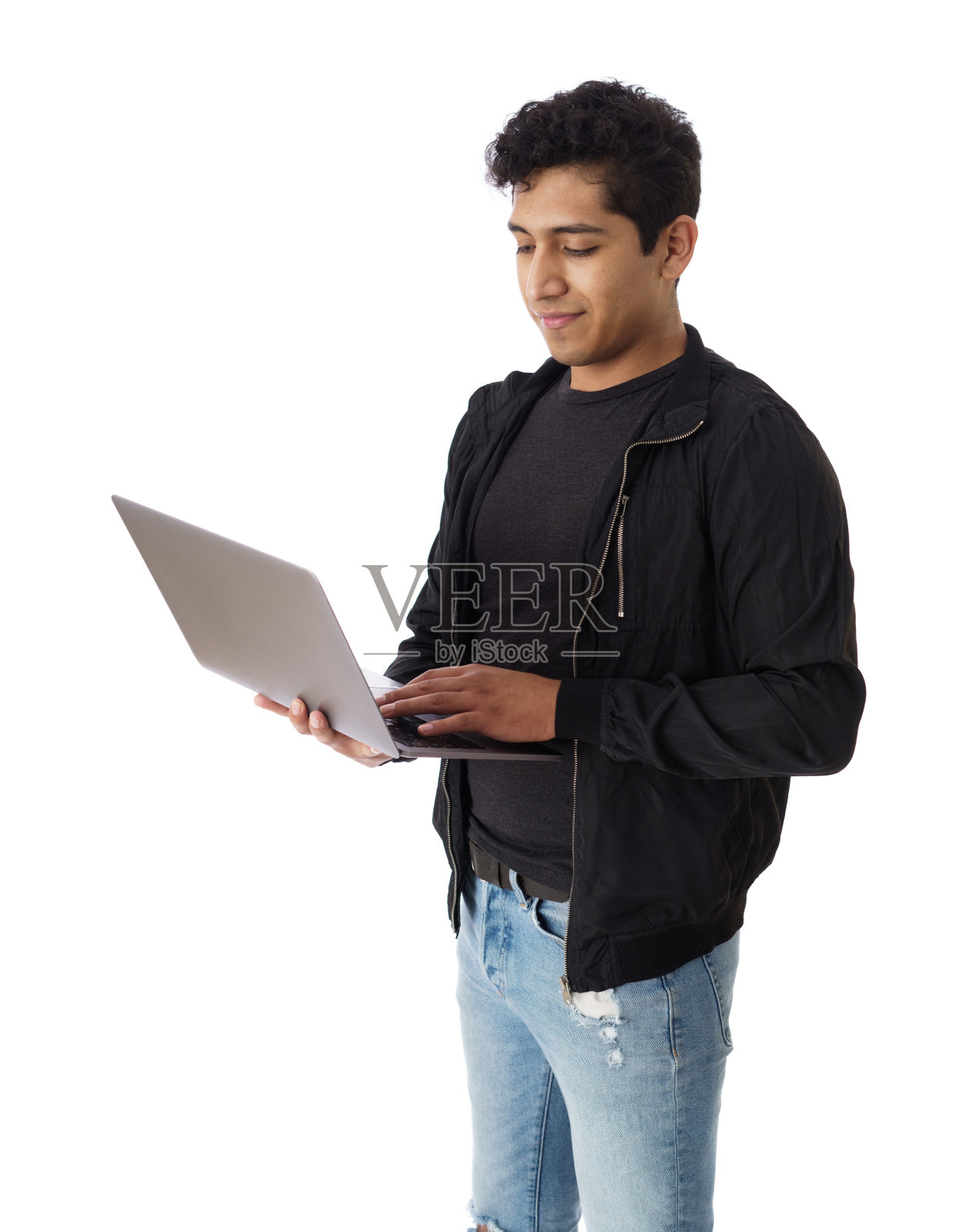 快乐的男学生在笔记本电脑上打字，面带微笑照片摄影图片