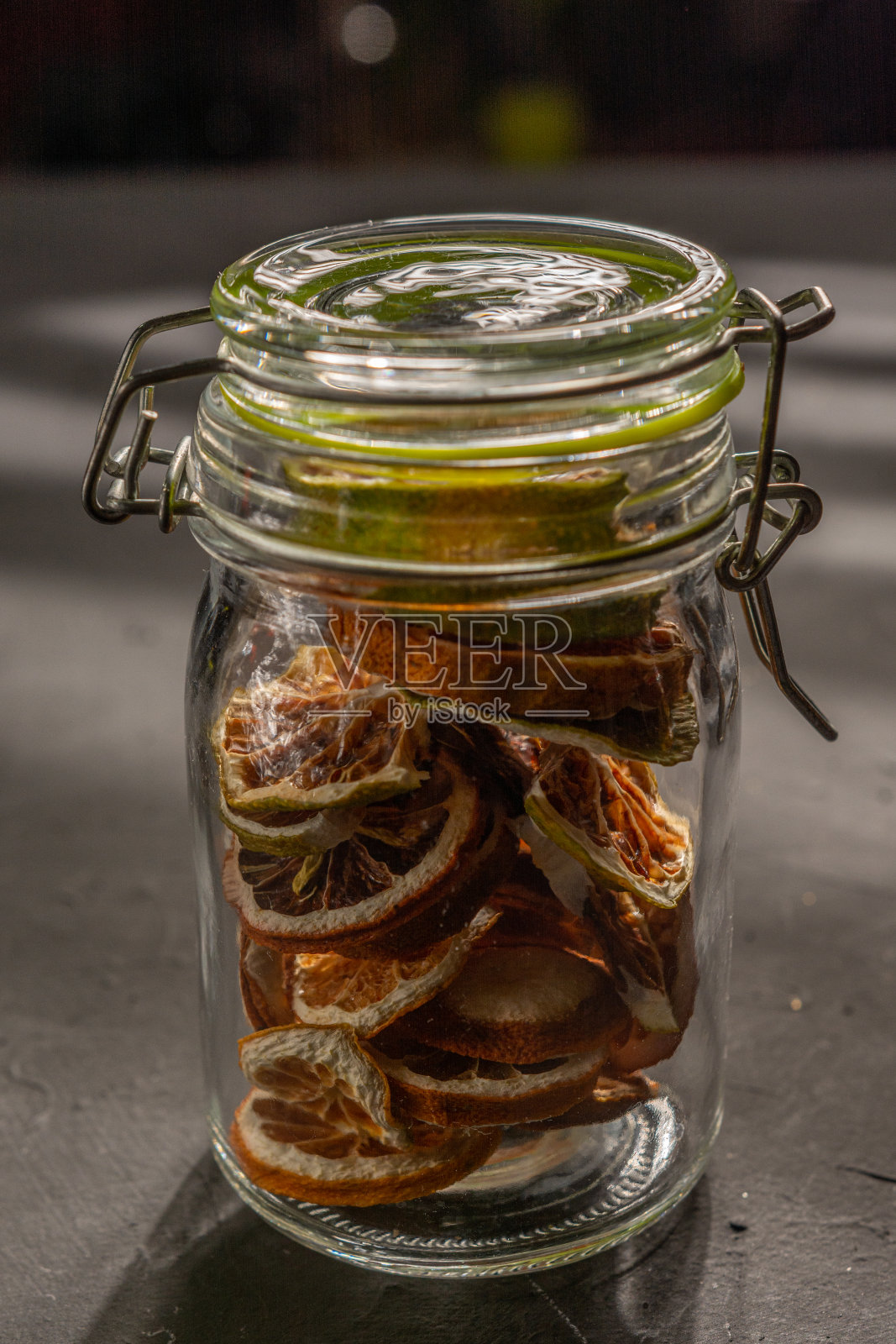 关闭玻璃罐中自制的脱水柠檬在黑色底部照片摄影图片