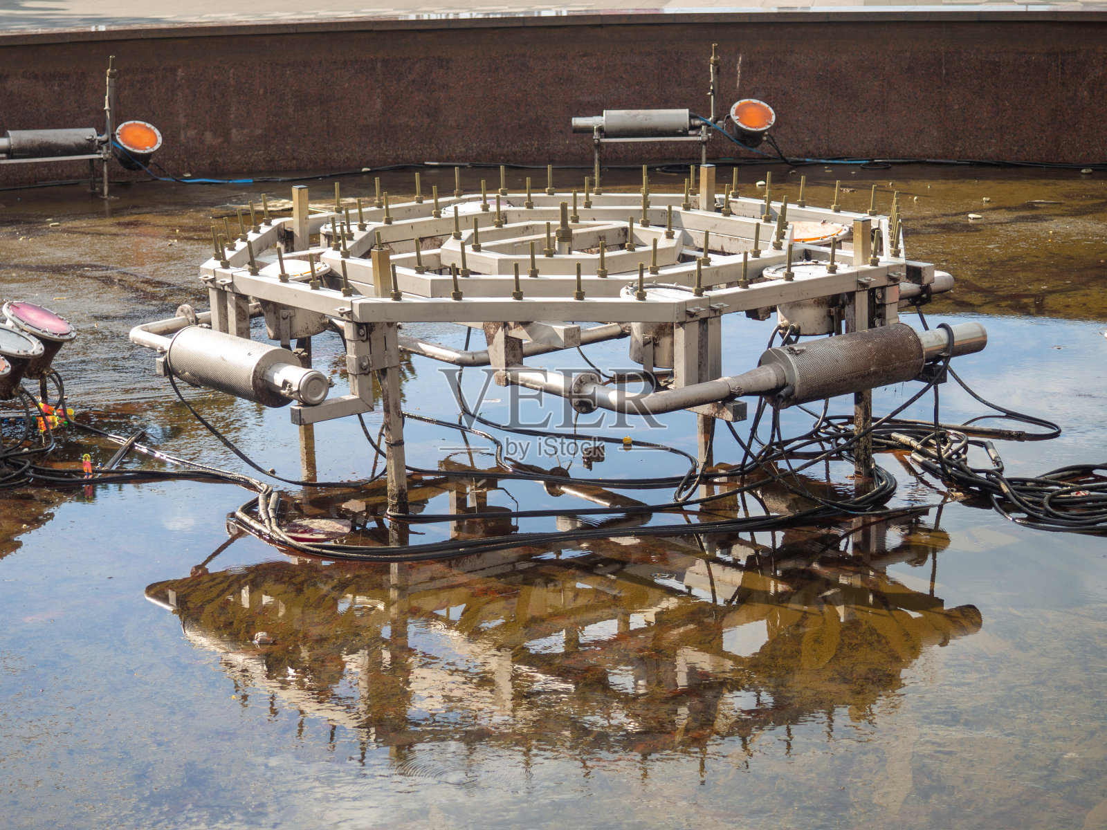 喷泉跳舞设备公园里的喷泉被抽干了。没有水。喷泉内的设备。照片摄影图片