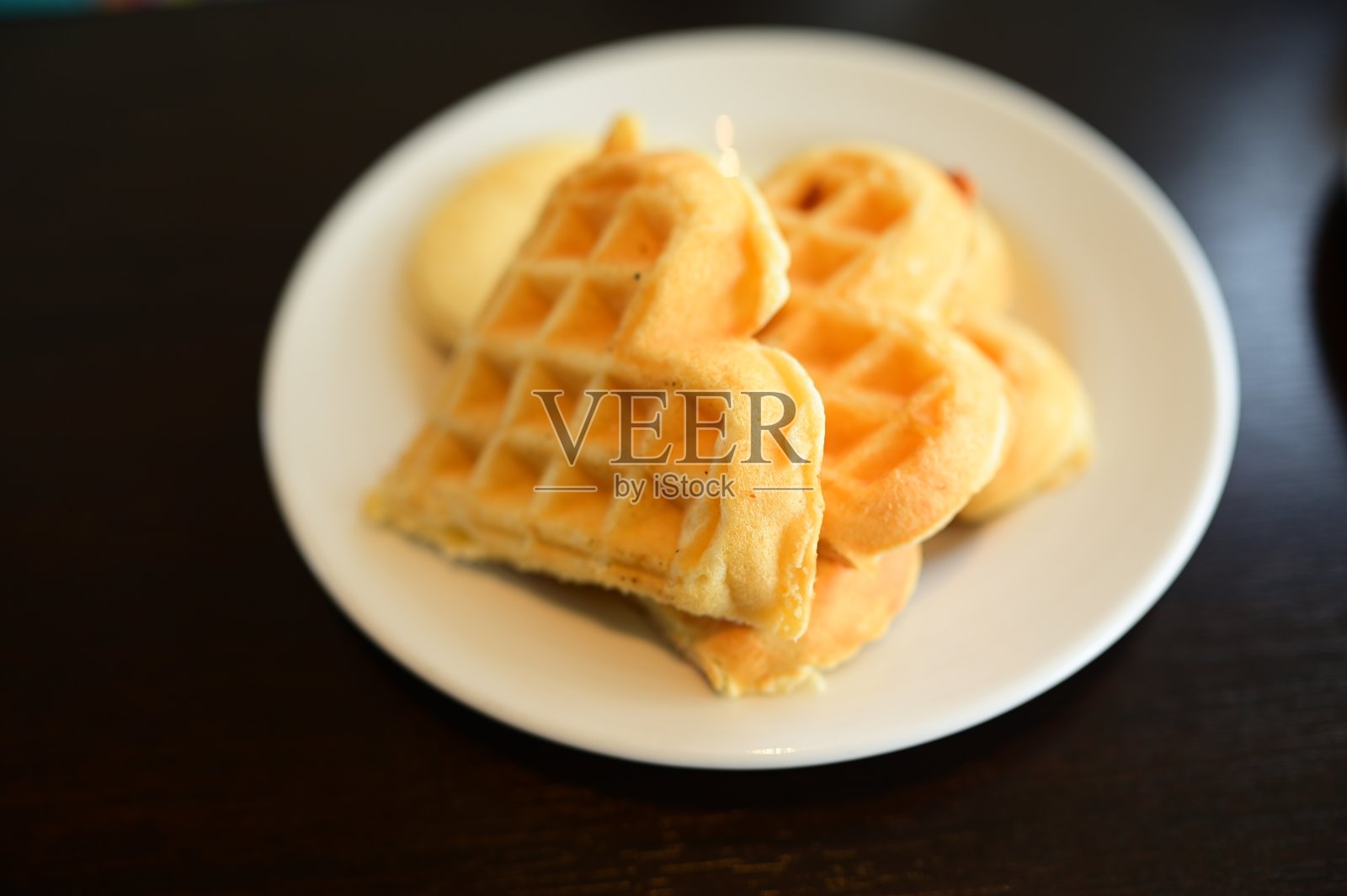 华夫饼和煎饼放在白色盘子里。照片摄影图片