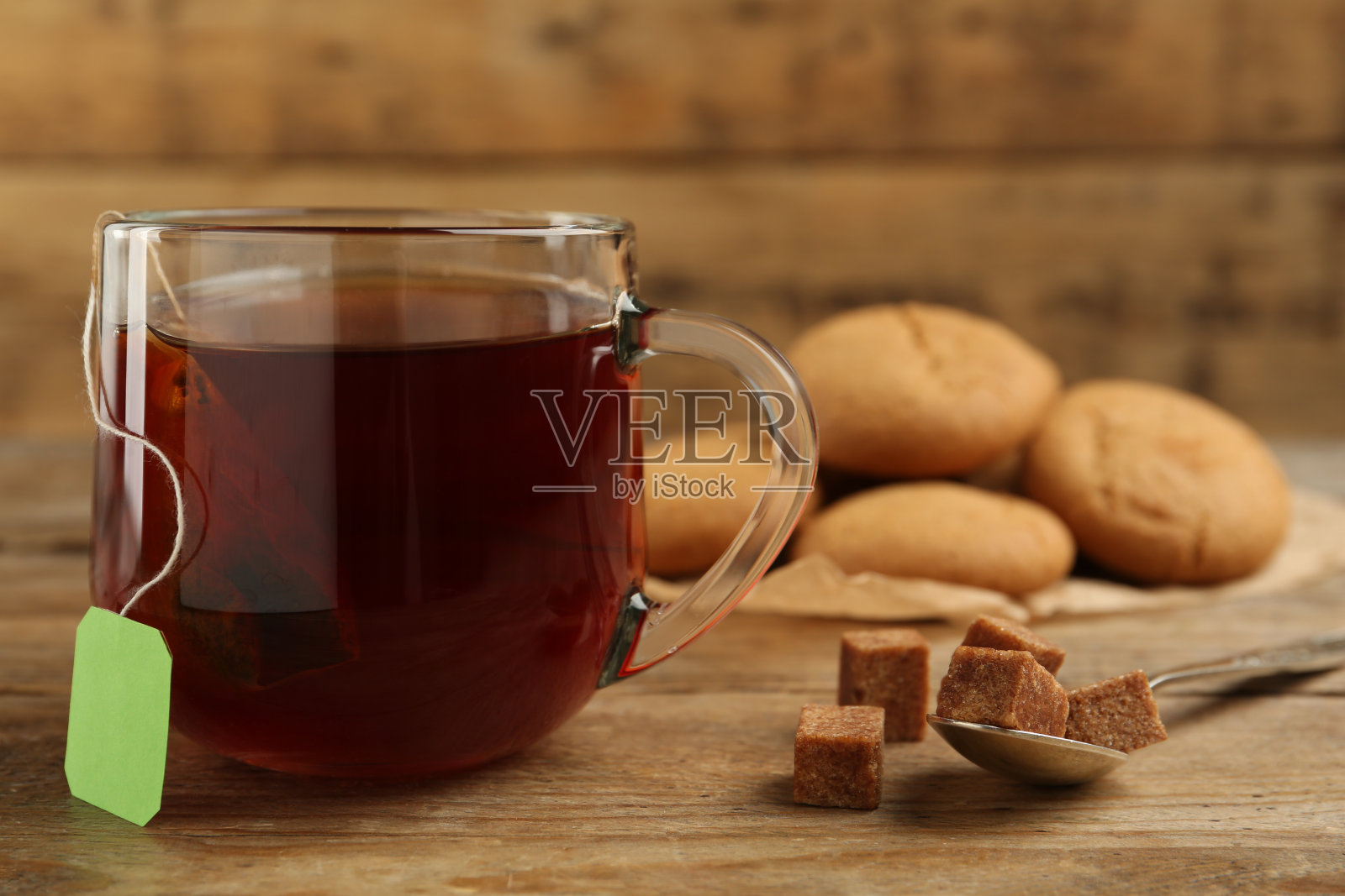 茶包放在杯子里的热水和糖放在木桌上，特写。空间的文本照片摄影图片