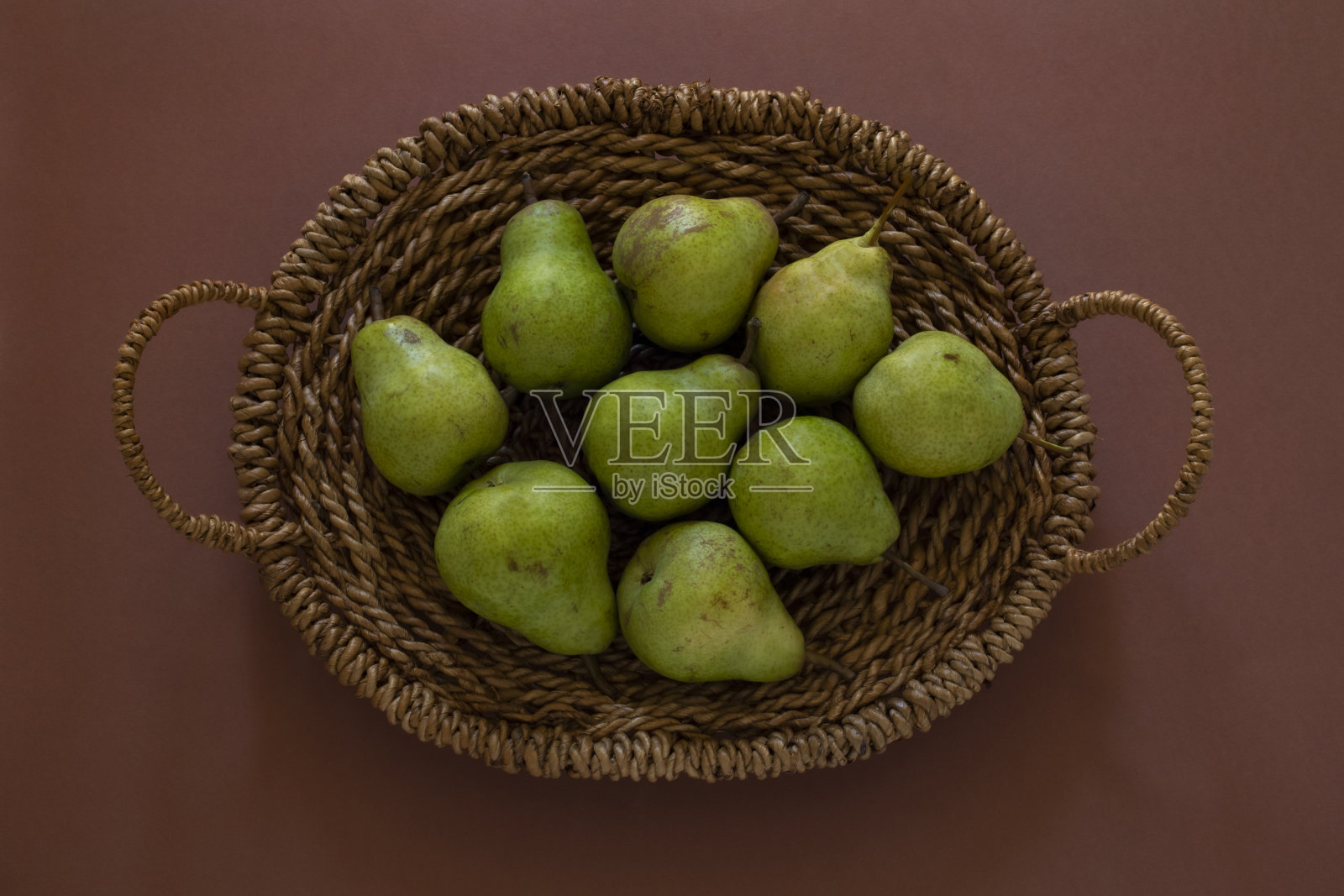 青梨在赤陶背景的篮子照片摄影图片