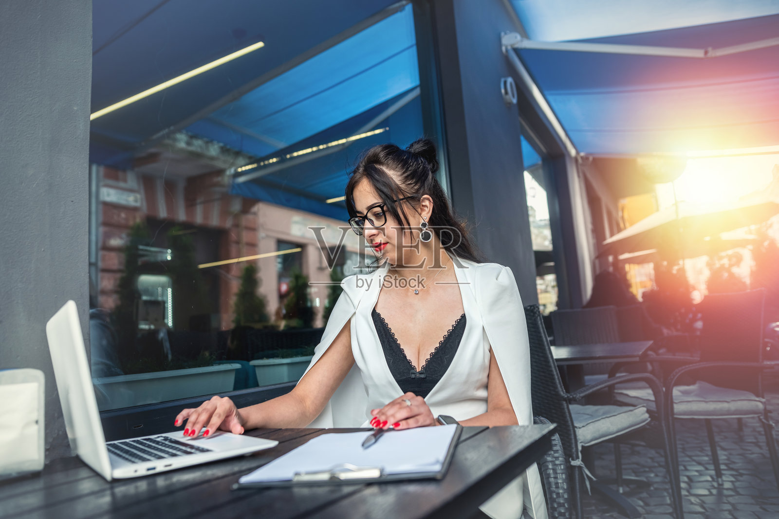 一个年轻的女商人坐在咖啡馆里，用笔记本电脑工作。照片摄影图片