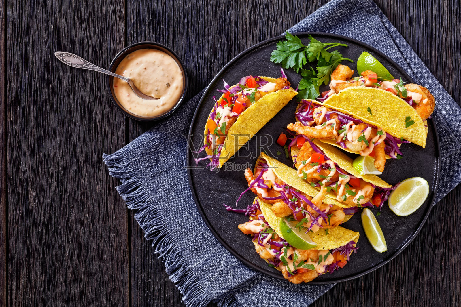 炸虾玉米饼，黑色盘子配酱汁照片摄影图片