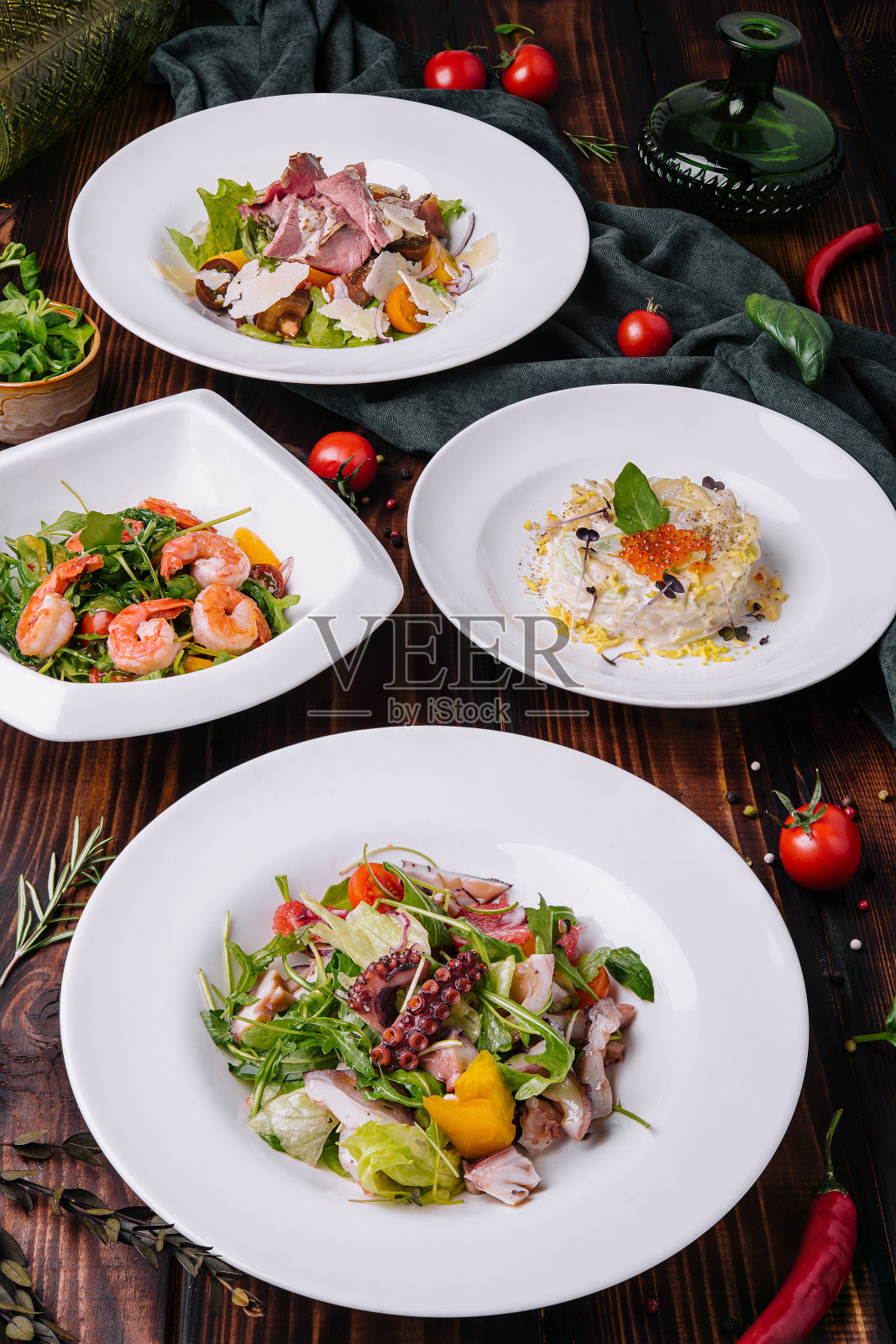 不同的沙拉装在白色盘子里，放在木桌上照片摄影图片