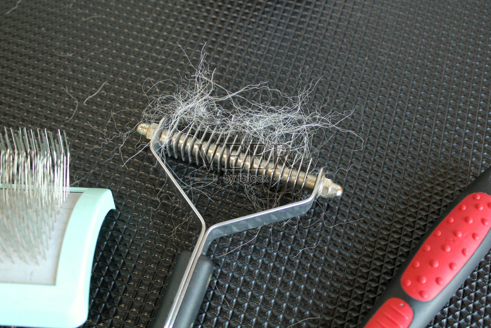 一套专业工具梳理动物后使用与狗在沙龙的黑色桌子背景皮毛照片摄影图片