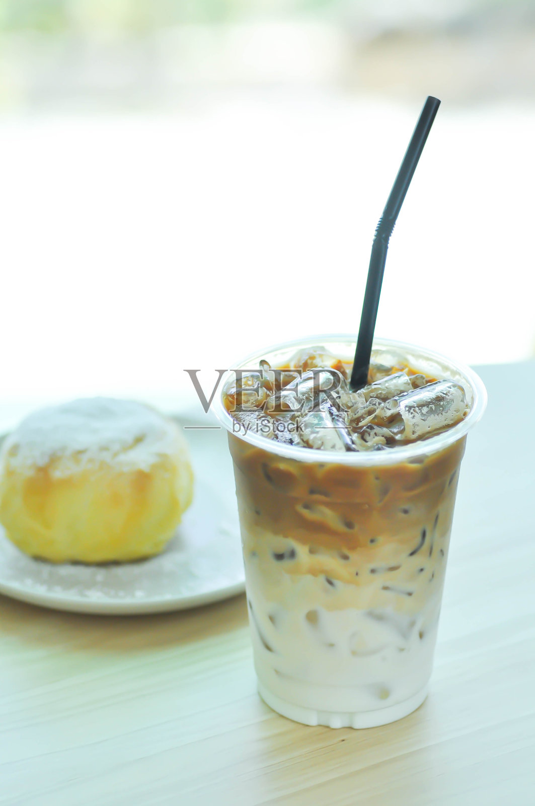 小圆面包、奶油小面包或黄油小面包，上面加糖粉或糖粉和冰咖啡照片摄影图片