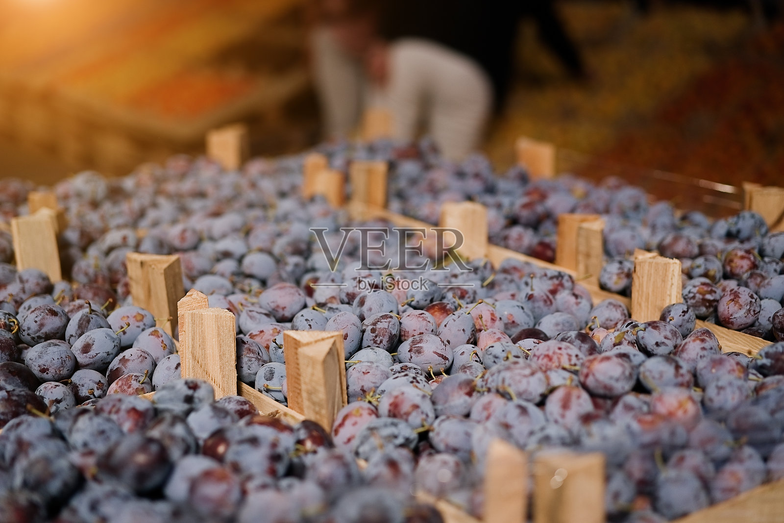 市场上出售的新鲜李子果盒。照片摄影图片