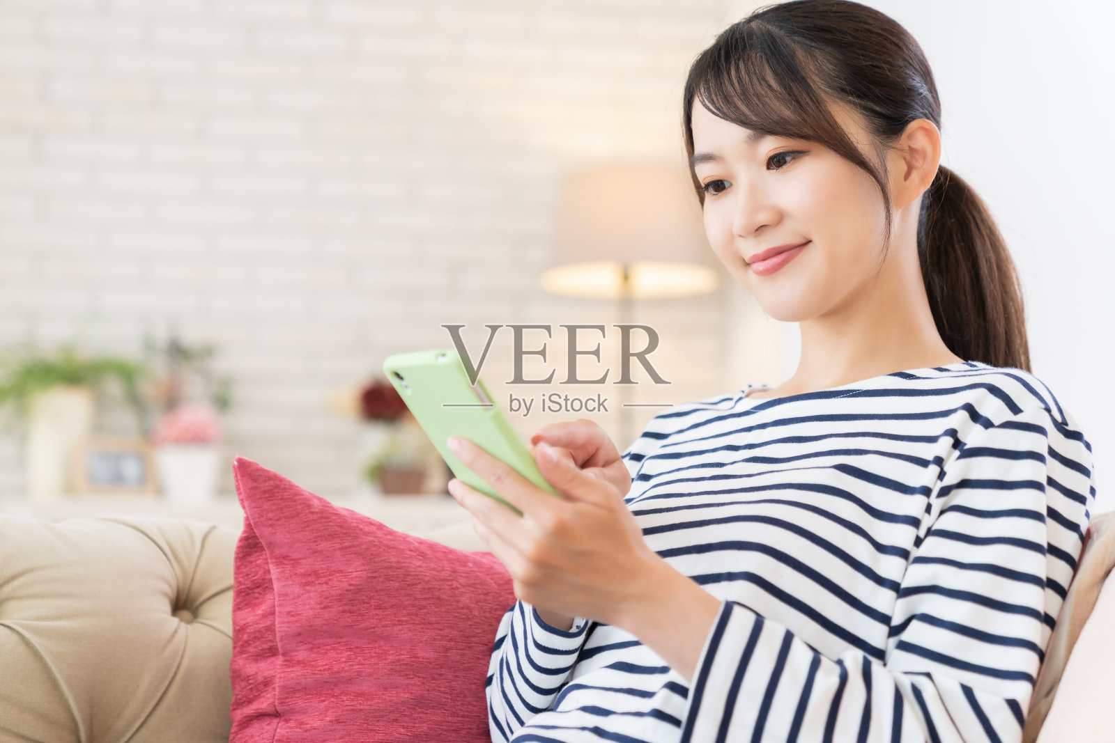 使用智能手机的迷人亚洲女性照片摄影图片