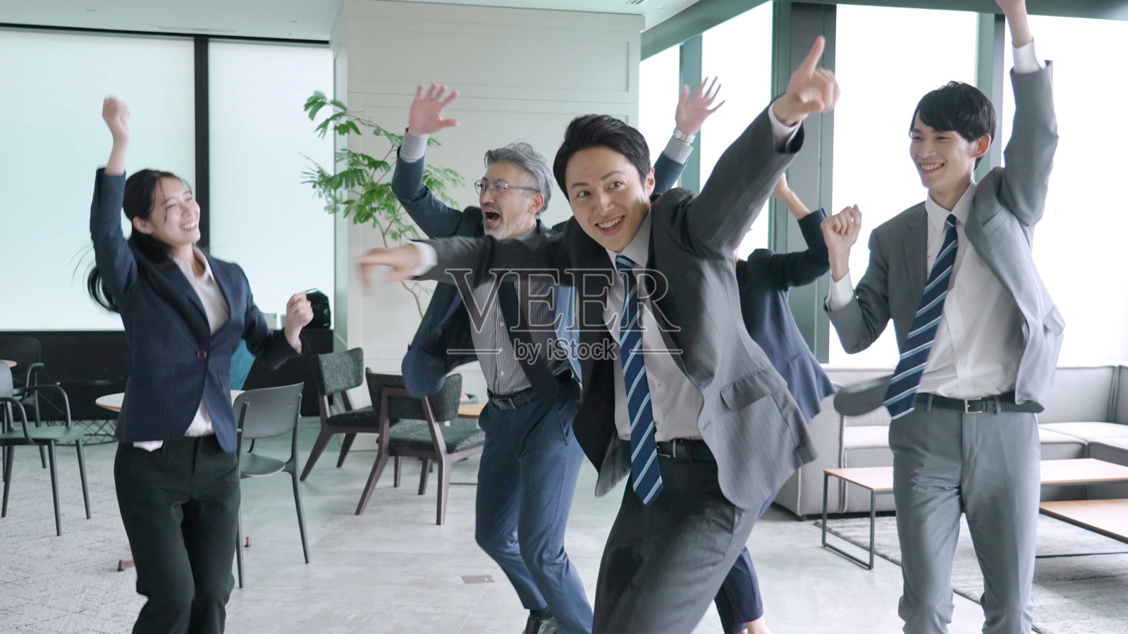 一群亚洲商人在办公室里跳舞照片摄影图片