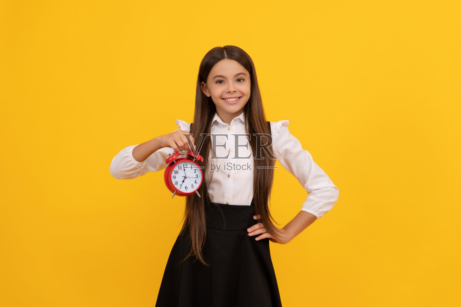 最后的机会。准时的少女检查时间。欢快的孩子带着闹钟。照片摄影图片