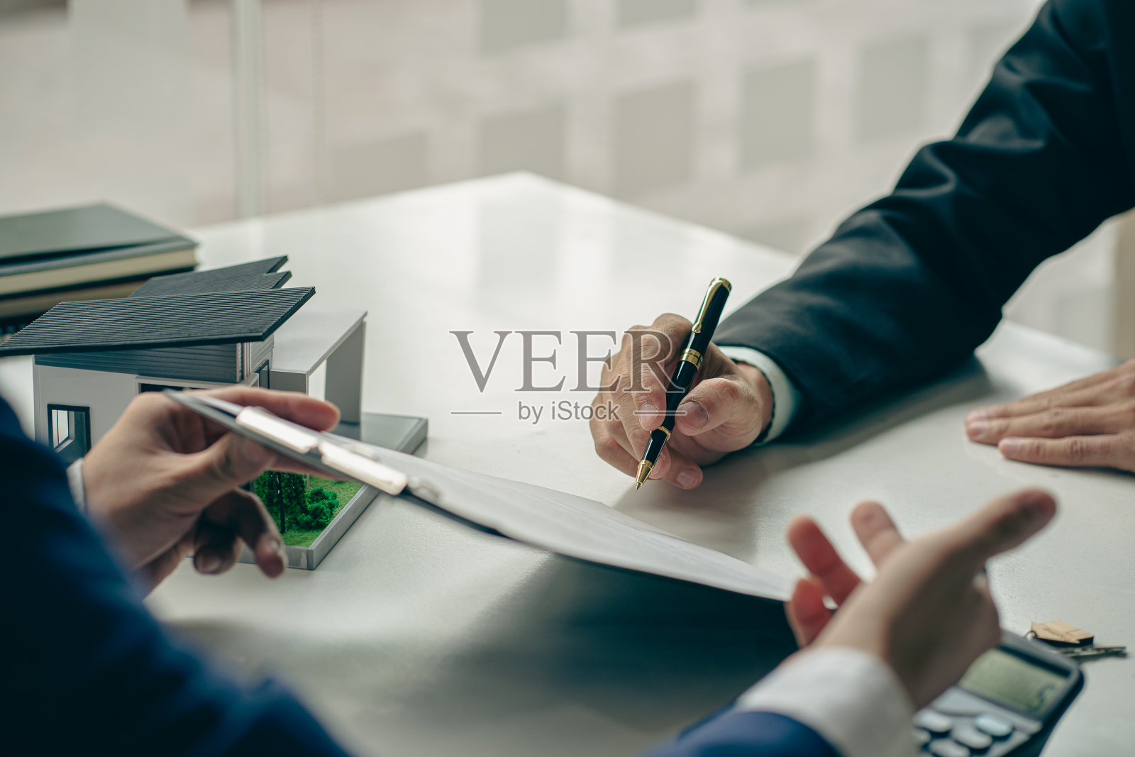 房屋中介与新购房者交谈，提供良好的利率，并计算客户的抵押贷款融资，以帮助做出房地产概念决策。照片摄影图片