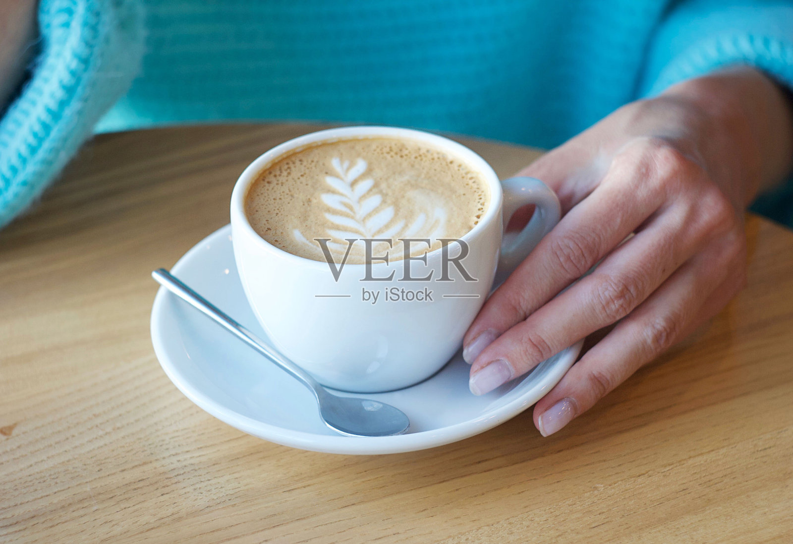 卡布奇诺在桌子上。女人要喝咖啡照片摄影图片