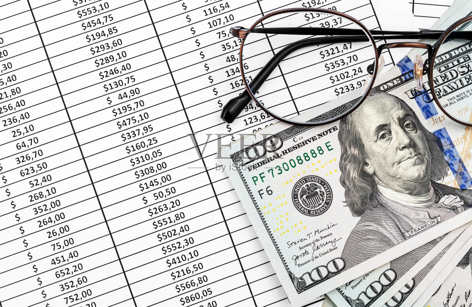 金融文件上印着美元钞票的眼镜。前视图。照片摄影图片