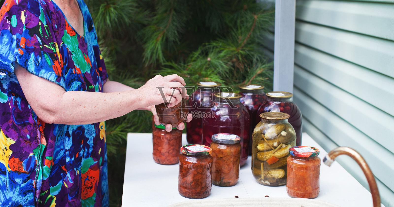 妇女关闭自制罐头果酱罐盖子的特写照片摄影图片