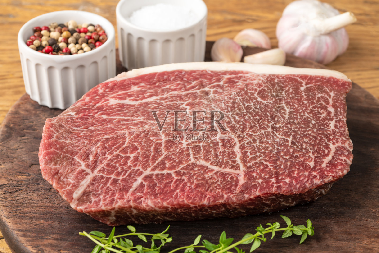 生的和牛肩肉放在木板上，加上调味料照片摄影图片