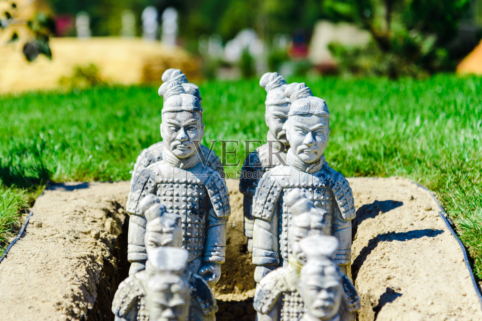 夏季绿草地上的兵马俑微型雕塑。telsiai立陶宛。08-11-2022。照片摄影图片