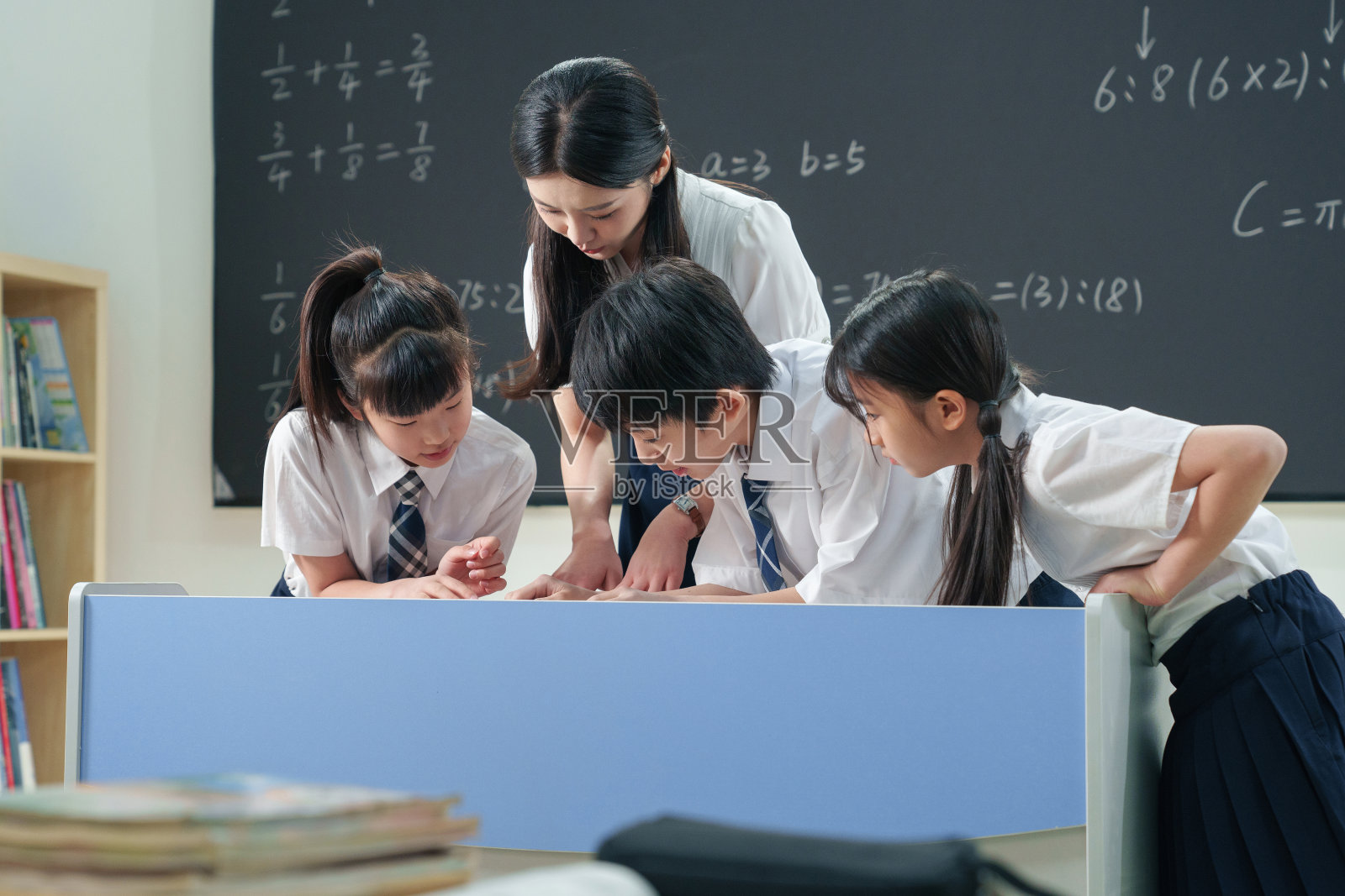 老师给小学生辅导学习照片摄影图片