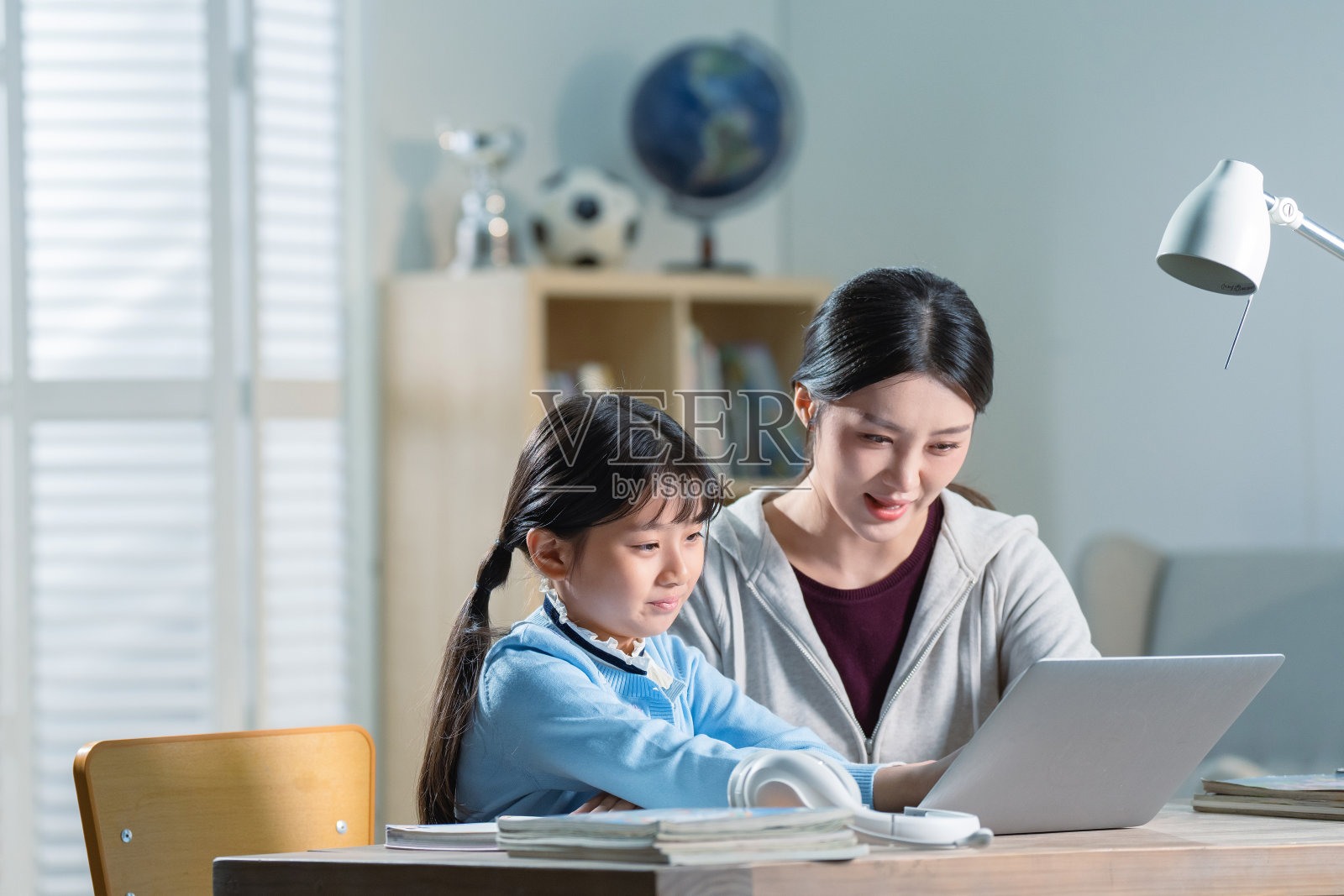 年轻妈妈辅导女儿学习照片摄影图片