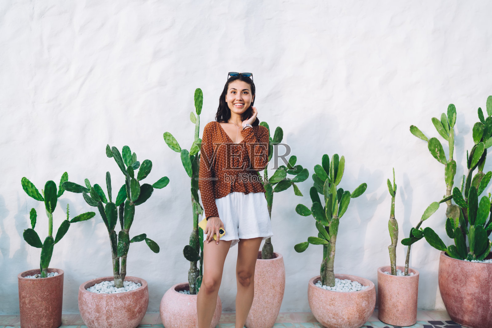 积极的亚洲女人站在白墙上照片摄影图片