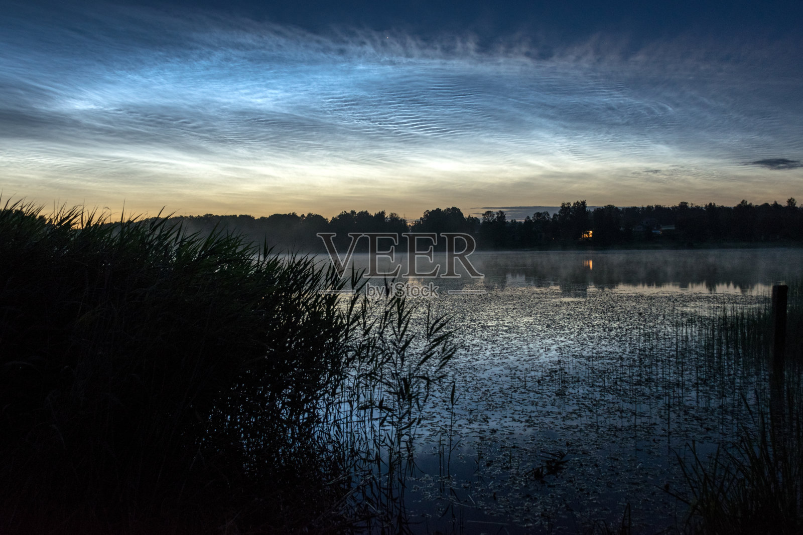 夜的景观与白色的银白色的云在湖面上，模糊的前景，迷人的云倒影在湖水，夏夜照片摄影图片