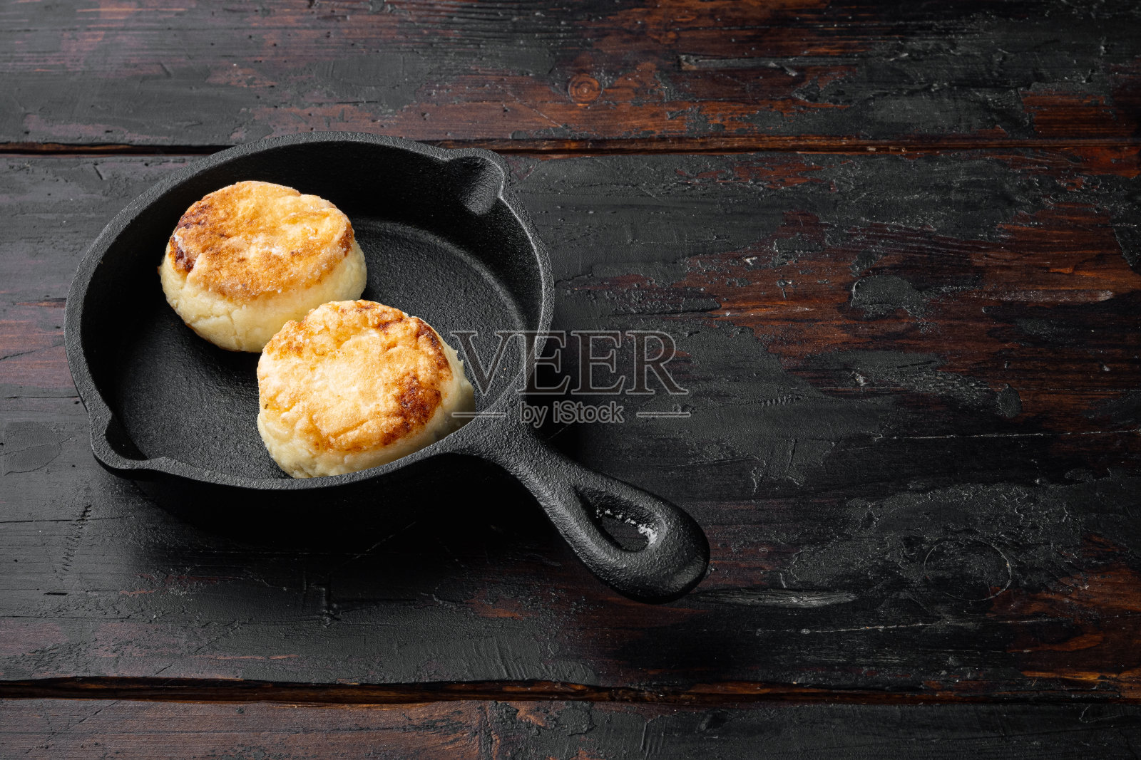 美味的乡村芝士煎饼在铸铁煎锅上，在铸铁煎锅煎锅，在黑色的木制桌子背景，文本的复制空间照片摄影图片