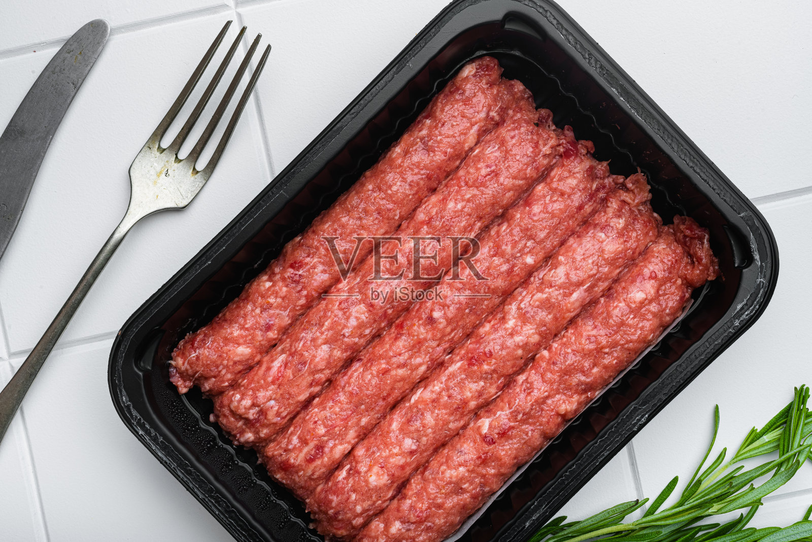 新鲜的生牛肉串，在白色陶瓷方格瓦的桌子背景，俯视图平铺照片摄影图片